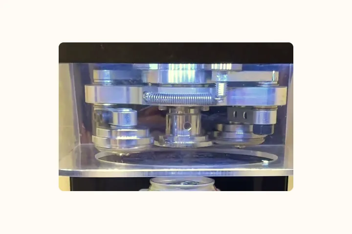 The sealing head of the can sealing machine, lowered over a can.